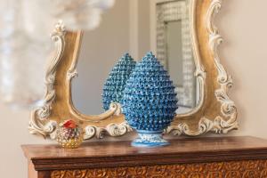 a blue vase on a table in front of a mirror at Hotel Soleluna in Piano di Sorrento
