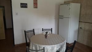 y cocina con mesa, sillas y nevera. en Departamentos ramallo, en Ramallo