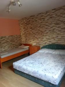 1 Schlafzimmer mit 2 Betten und Ziegelwand in der Unterkunft Otok Krk Apartments in Čižići