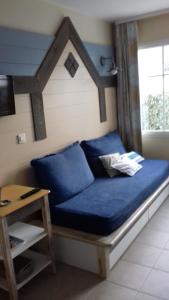 a blue couch in a room with a window at Résidence Marie Galante Locmaria avec piscine in Locmaria