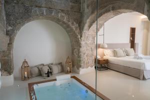 - une chambre avec un lit et une baignoire dans l'établissement Masseria Amastuola Wine Resort, à Crispiano