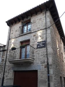 - un bâtiment en briques avec un balcon et un panneau sur celui-ci dans l'établissement El Cobijo de los Arribes, à Fermoselle