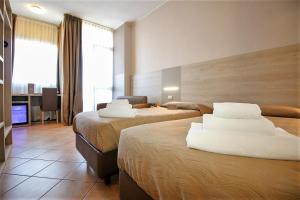 a hotel room with two beds with white pillows at Hotel Miramonti in Turin