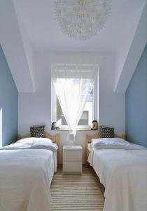 ウケンチンにあるChill&Sunの窓とシャンデリアが備わる客室で、ベッド2台が備わります。