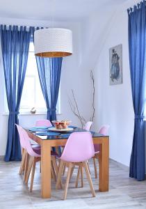 a dining room with a table and pink chairs at Chill&Sun in Łukęcin