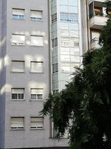 オウレンセにあるVivienda Caseiroの窓が多く並ぶ高層ビル