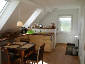 a kitchen with a table and a dining room at Ferienhaus-Uckermarkblick in Rosenow