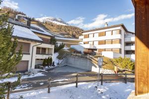 a building with snow on the ground in front of it at Chesa Sarvit - Celerina in Celerina