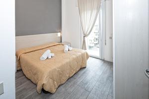 ein Schlafzimmer mit einem Bett mit zwei Handtüchern darauf in der Unterkunft Residence Rimini Mare in Rimini
