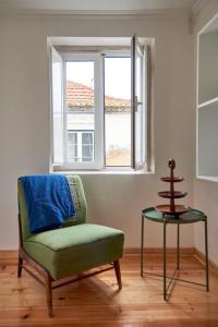 リスボンにあるSpacious Duplex with Terraceの窓のある部屋(椅子、テーブル付)