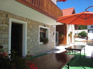 eine Terrasse mit einem Tisch und einem Sonnenschirm in der Unterkunft Sixteen Lakes Guest House 2 in Jezerce