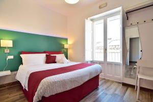 a bedroom with a large bed and a large window at Modica Old Town Rooms - Self check-in in Modica
