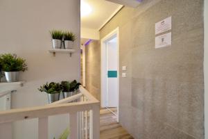 un corridoio con piante in vaso sul muro di Modica Old Town Rooms - Self check-in a Modica