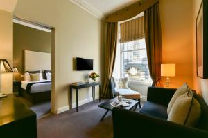 a hotel room with a bed and a living room at Fraser Suites Edinburgh in Edinburgh