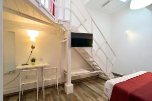 a room with a staircase with a tv and a bed at Modica Old Town Rooms in Modica