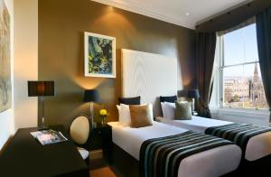 a hotel room with two beds and a window at Fraser Suites Edinburgh in Edinburgh