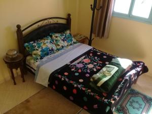 sypialnia z łóżkiem i wzorzystym kocem kwiatowym w obiekcie Azur Tafraout w mieście Tafraout