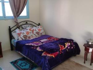 - un lit avec une couette et des oreillers bleus dans une chambre dans l'établissement Azur Tafraout, à Tafraout
