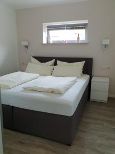a bedroom with two beds with white sheets and a window at FeWo an der Ostsee Nr. 5 in Rerik