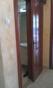 a bathroom with a wooden door and a sink at Apartment 60m from sea! in Nea Kalikratia +13 photos