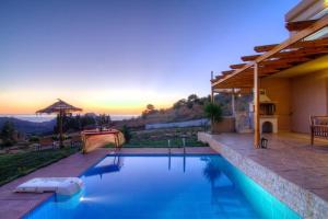a swimming pool in a house with a sunset in the background at Villa Despina 2 Plakias Private Villa, Private Swimming Pool Garden, Panoramic Sunset in Asómatoi