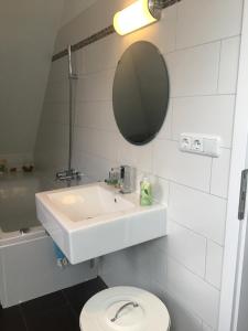 a bathroom with a sink and a toilet and a mirror at Helle und ruhige Dachgeschosswohnung in Munich