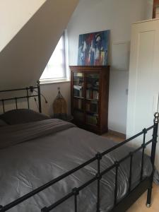 ein Schlafzimmer mit einem Bett und einem Bücherregal in der Unterkunft Helle und ruhige Dachgeschosswohnung in München