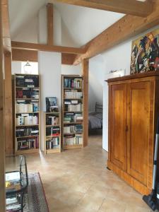 uma sala de estar com estantes de livros e um quarto em Helle und ruhige Dachgeschosswohnung em Munique