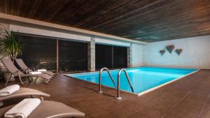 una piscina in una camera con vista sulla città di Frieden DAS Alpine Panorama Hotel a Pill