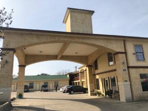 un gran edificio con un coche aparcado en un aparcamiento en Pinn Road Inn and Suites Lackland AFB and Seaworld, en San Antonio