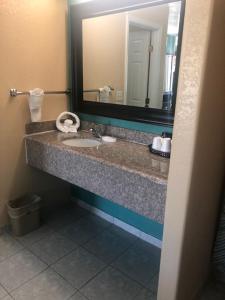 a bathroom with a sink and a mirror at Pinn Road Inn and Suites Lackland AFB and Seaworld in San Antonio +15 photos