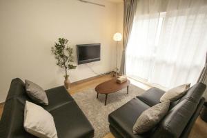 a living room with a couch and a tv at Bios Hall / Vacation STAY 2175 in Sapporo