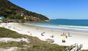 a group of people on a beach near the ocean at Apartamento Cobertura Duplex in Bombinhas