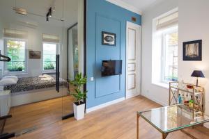 a room with a blue wall with a bed and a glass table at Deluxe Prince Machabeli Suite in Tbilisi City