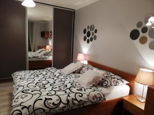 シュチェチンにあるSAS Apartamenty "Sapphire"のベッドルーム(白黒のベッド1台、鏡付)