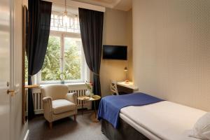 ストックホルムにあるパーラン ホテルのベッド1台、椅子、窓が備わる客室です。