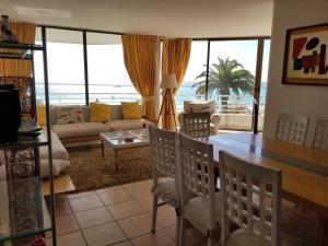 sala de estar con mesa, sillas y sofá en San Alfonso del Mar Frente al Mar, en Algarrobo