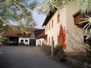 una calle frente a un edificio con un árbol en Ferienwohnung Biobauernhof Peter Anderl Hof, en Pfreimd
