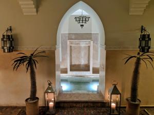 a swimming pool in a room with two palm trees at Dar Andamaure in Marrakesh