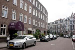 a row of cars parked on a street in front of buildings at Budget Trianon Hotel in Amsterdam