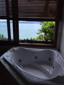 a bath tub in a room with a window at Casa na praia in Mangaratiba