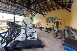 un gimnasio con varias cintas de correr y bicicletas estáticas en Ilhaflat ilhabela -Apartamento Schiavetti, en Ilhabela