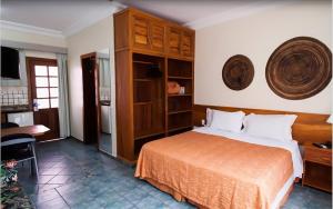 a bedroom with a bed and a table and a desk at Ilhaflat ilhabela -Apartamento Schiavetti in Ilhabela