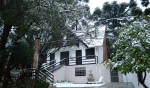 een wit huis met een trap ervoor bij Hotel Pousada Dos Pinheiros in Canela
