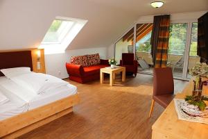 1 dormitorio con 1 cama y sala de estar en Landgasthof Adler Pelzmühle, en Biederbach Baden-Württemberg