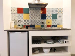 a kitchen with colorful tiles on the wall at Alice in Wonderland in Naples