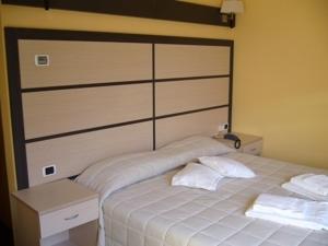 a bedroom with a bed with two pillows on it at Hotel La Solitaria in Carlazzo