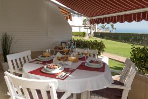 サンアグスティンにあるFirst Line Seasideのパティオの白いテーブル(料理、ワイン付)