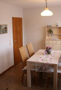 - une salle à manger avec une table, des chaises et une porte dans l'établissement Birkenweg Ankerplatz II, à Carolinensiel