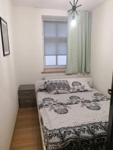 a small bedroom with a bed and a window at Apartamenty Górskie LĄDEK-ZDRÓJ in Lądek-Zdrój